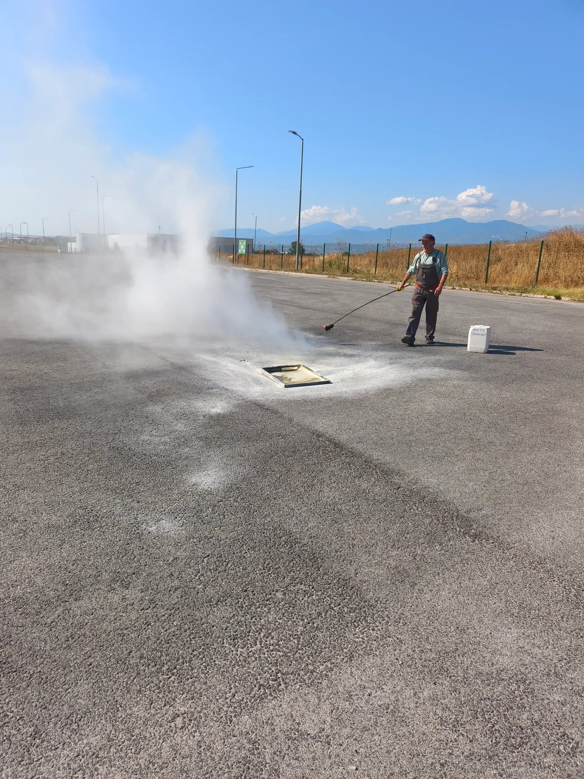 An employee extinguishing a controlled fire with an extinguisher during outdoor fire safety training